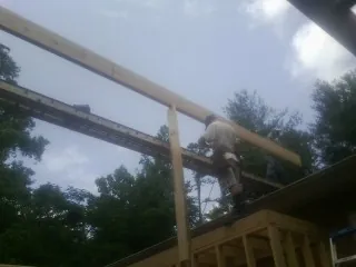 Carpenter setting a ridge beam over a new addition frame — Ice Dam Removal by Roofing Brothers in Eagle Point