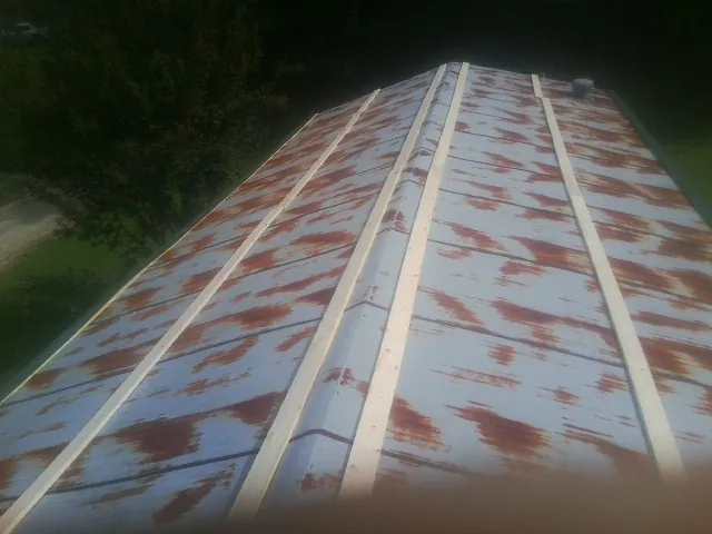 Rusted metal roof panels with new wood purlins before replacement — Storm Damage Roof Repair in Eagle Point by Roofing Brothers
